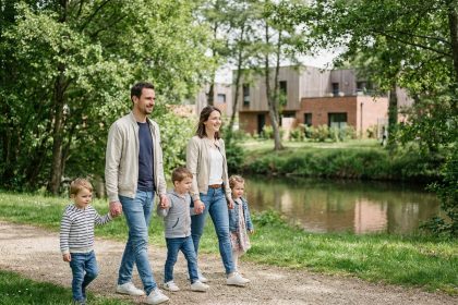 Famille heureuse se promenant au bord de la rivi&egrave;re au printemps