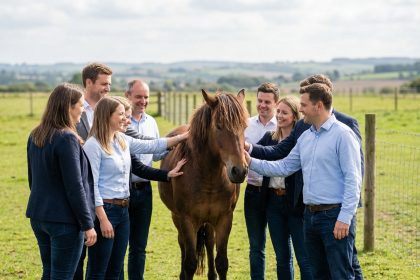 Groupe divers de personnes avec un cheval en prairie